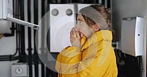 Woman adjusts heating temperature in the boiler room