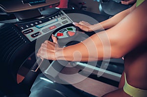 Woman adjusts the treadmill at the beginning of training