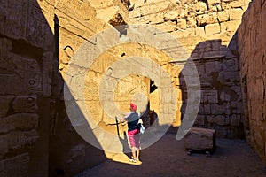 Woman admires amazing engraved hieroglyphic pictures on the walls of the Luxor Temple in Egypt