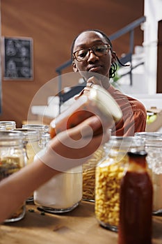 Woman admires jar of red food product