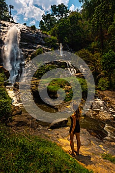 Woman admires Wachirathan waterfall in Doi Inthanon National Park near Chiang Mai Thailand