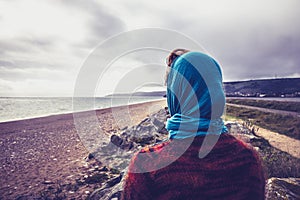 Woman admiring the sea on a cold autumn day