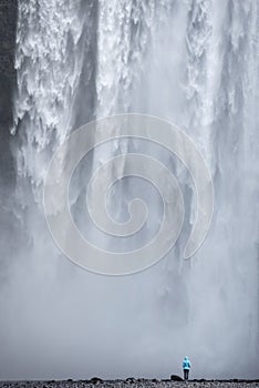 Woman admiring Skogafoss waterfall in Iceland