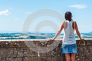 Woman admiring the summer Italian landscape in Montepulciano