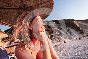 Woman admiring the sunset at Myrtos beach at Cefalonia island, Greece photo