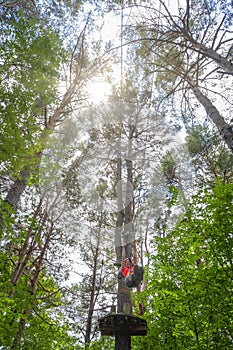 Woman in an adventure park jumping on a zip line