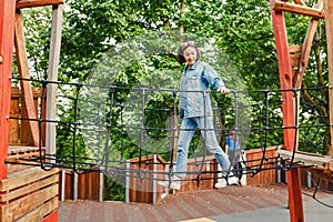 Woman in an adventure rope park at children playground