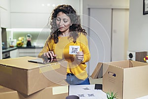 Woman affixing QR codes onto storage boxes. Concept organization, efficiency, or technology in storage management photo
