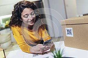 Woman affixing QR codes onto storage boxes. Concept organization, efficiency, or technology in storage management photo