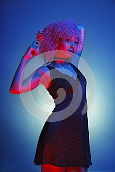 Woman with afro hair dancing with a nightlife dress surrounded b