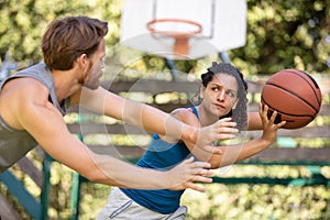 woman against man couple playing basketball