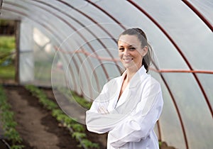 Woman agronomist with crossed arms in greenhose