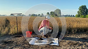 Woman agronomy specialist preparing for soil testing with soil tester