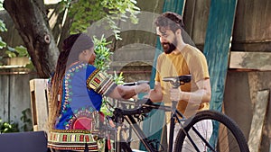 Woman aiding man in fixing bicycle