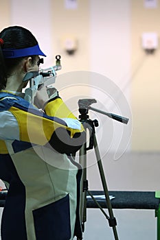 Woman aiming a pneumatic air rifle