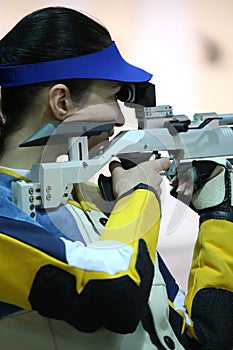 Woman aiming a pneumatic air rifle