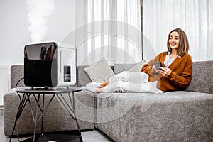 Woman with air humidifier at home