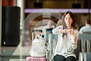 Woman in an airport lounge waiting for flight. Caucasian tourist looking for time in the waiting room