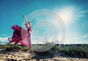Woman in airy dress running on the beach