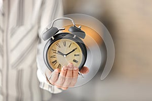 Woman with alarm clock, closeup. Time management concept