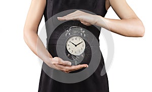 Woman with alarm clock between hands, isolated on white, magic