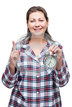 A woman with an alarm clock in her hand at 7 o& x27;clock