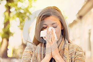 Woman with allergy symptoms blowing nose