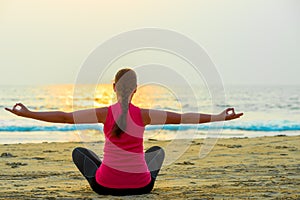 Woman alone does yoga at sunset