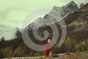 Woman alone looks at desolate mountains