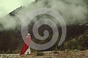 Woman alone looks at misty mountains