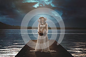 Woman alone on surreal lake pier