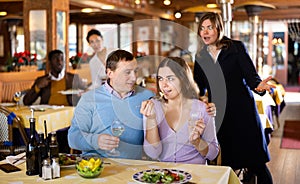 Woman amazed by looking at her husband dining with his mistress