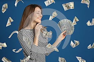 Woman with American dollars under money rain on background