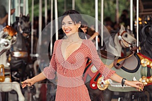 Woman in amusement excited and happy waiting for the ride at carousel