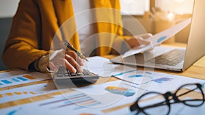 The woman analyzing financial data with a calculator and laptop in a bright office..AI generated image
