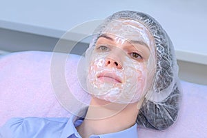 Woman with anesthetic cream on face skin before biorevitalization for numbing. photo