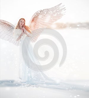 Woman angel with wings in the winter. Snow angel standing in the snow, the Keeper of winter, a fabulous image.