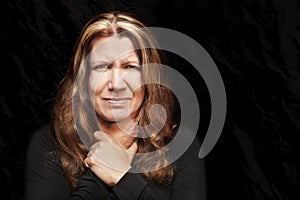 A woman with an angry face in a black T-shirt on a black background