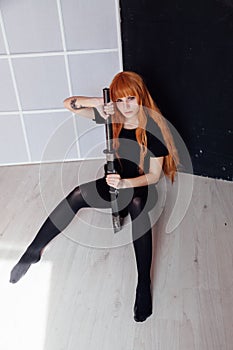 Woman anime cosplayer with red hair Japanese sword