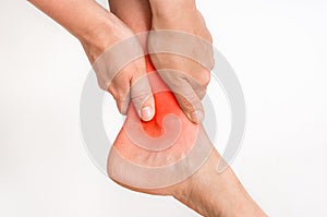 Woman with ankle pain holding her aching leg photo