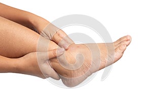 Woman with ankle pain using two hands holding leg and massaging painful her on isolated