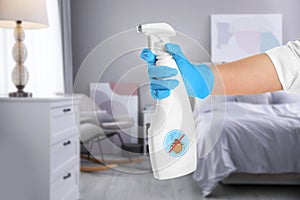 Woman with anti bed bug spray in bedroom, closeup