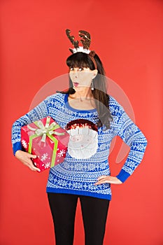 Woman in antlers tiara holding Christmas gift