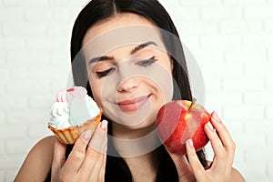 Woman with apple closeup face. Beautiful women exists to clean skin on the face that chooses to eat an apple or cake. Asian