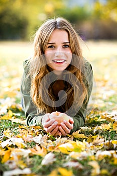 Woman with apple outdoors in autumn