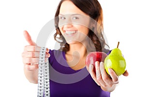 Woman with apple, pear and measuring tape