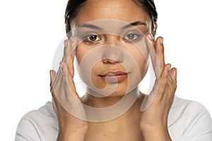Woman applies concealer under her eyes