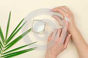 A woman applies moisturizer to hands
