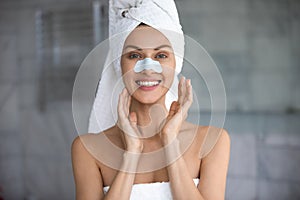 Woman apply cleansing pore nose strips smiles looks at camera