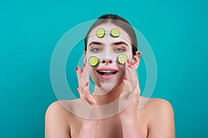 Woman apply facial mask isolated over blue studio background. Spa, cosmetic mask. Beautiful woman with clay facial mask